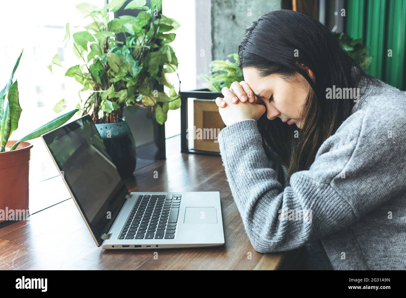 Exhausted caucasian student working on laptop, suffering from headache or migraine. Stock Photo