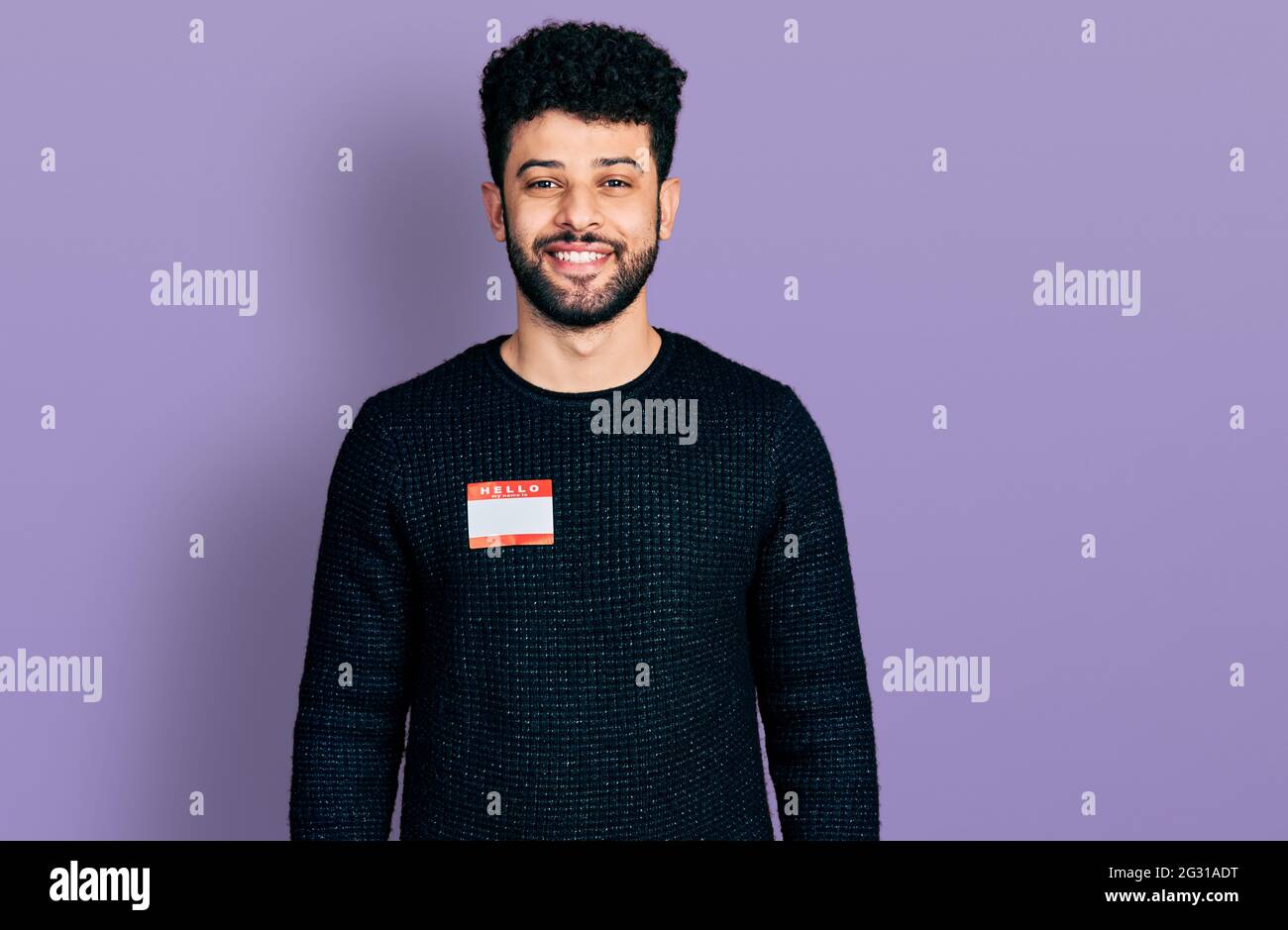 Young arab man with beard wearing hello my name is sticker ...