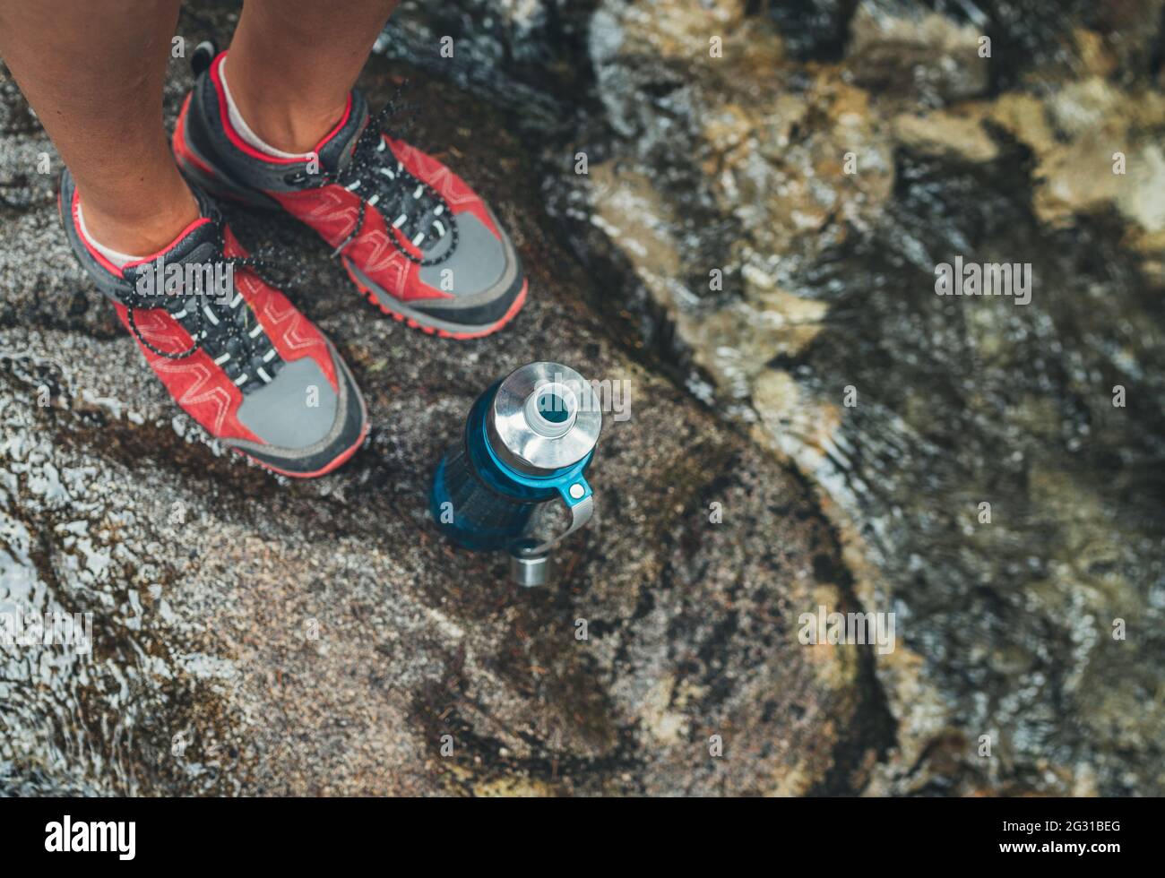 Female feet in trekking boots top view with plastic touristic bottle filled  up with fresh mountain stream water while drinking break on tourist hiking  Stock Photo - Alamy