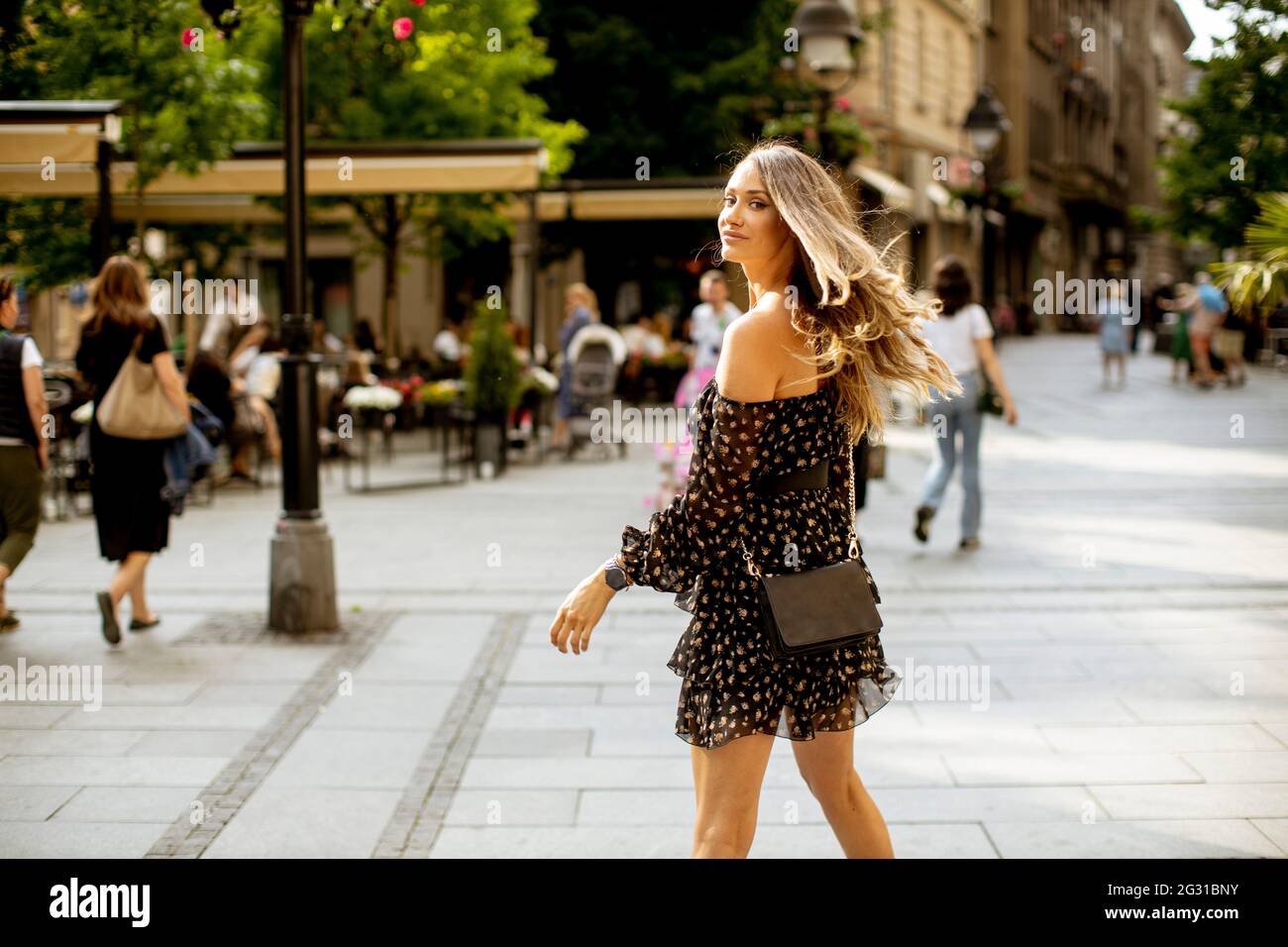 Pretty young long hair brunette woman walking on the city street Stock ...