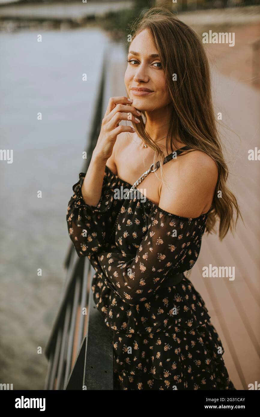 Pretty young long hair brunette woman standing on the riverside Stock ...