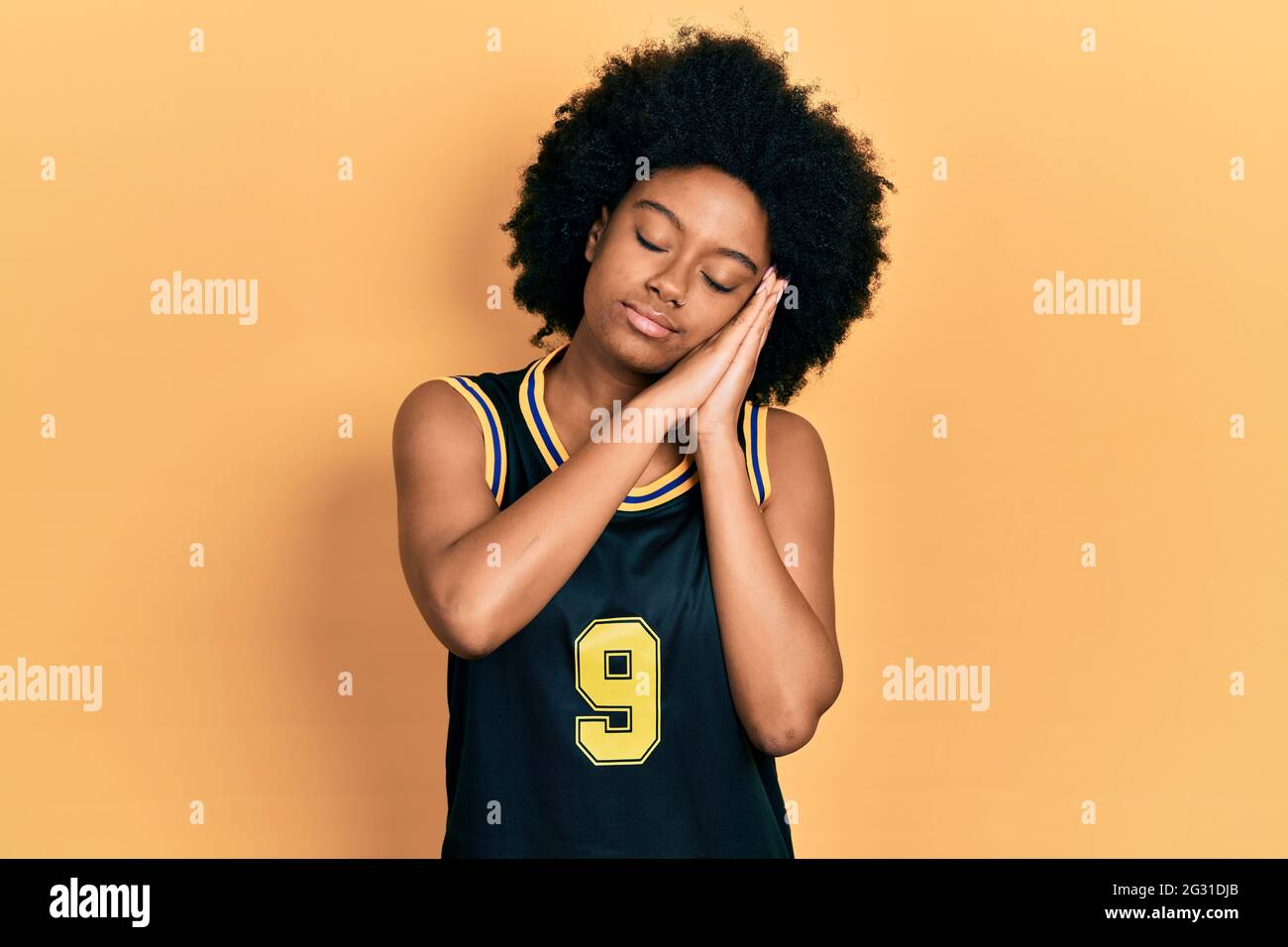 Young african american woman wearing basketball uniform sleeping tired  dreaming and posing with hands together while smiling with closed eyes  Stock Photo - Alamy