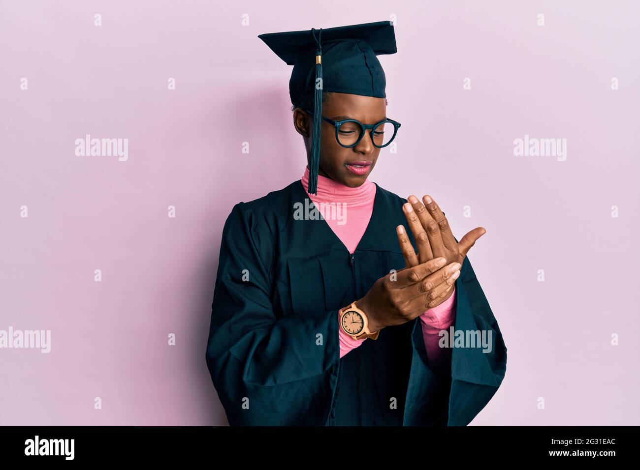 Young african american girl wearing graduation cap and ceremony robe ...
