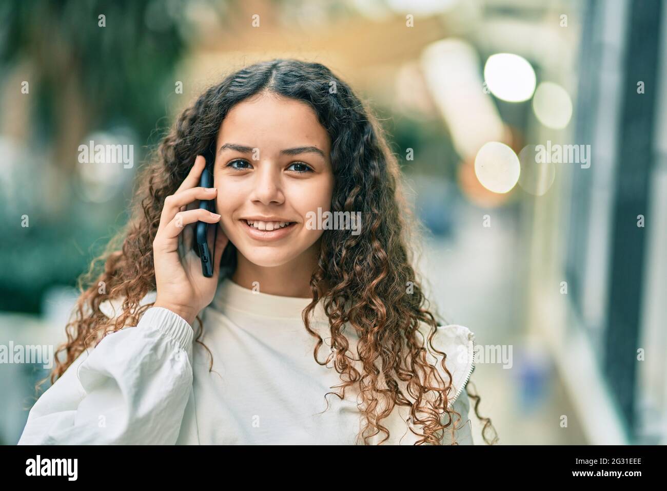 Beautiful hispanic girl smiling happy talking on the smartphone at the ...