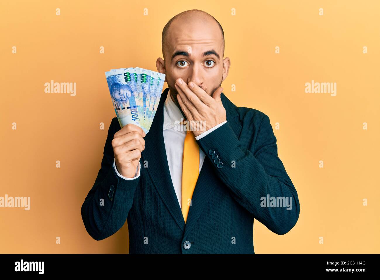 Young hispanic business man holding south african 100 rand banknotes