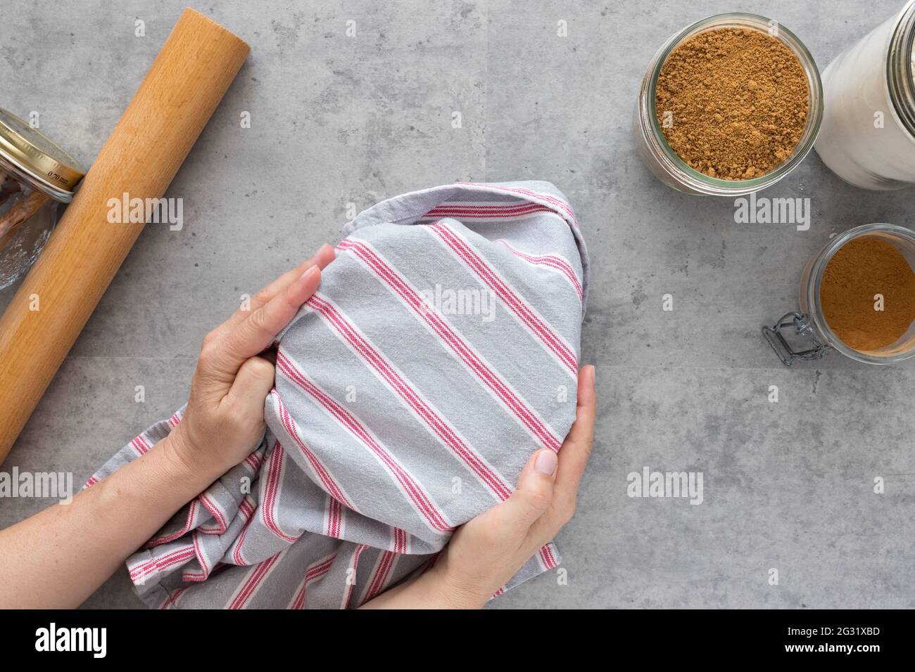 Woman hands covering some cinnamon roll dough to make it to rise. Stock Photo
