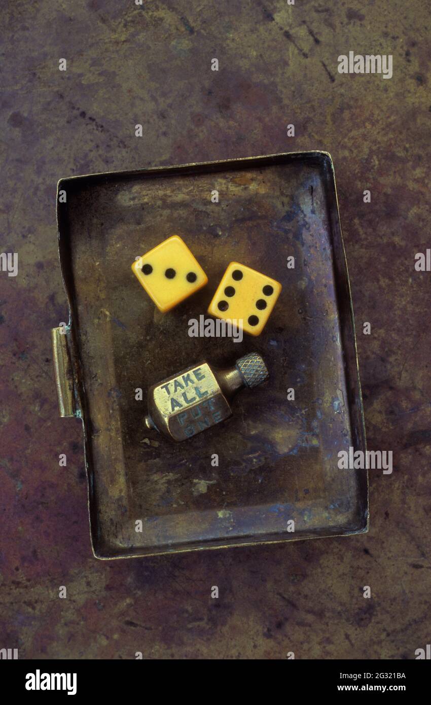 Old brass box containing two vintage dice and brass spinner revealing