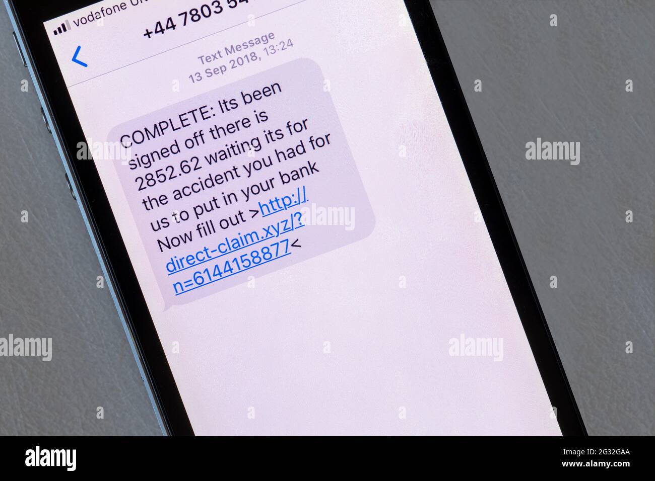 A scam message displayed on an iphone that pretends to be about payment from an insurance claim. Stock Photo