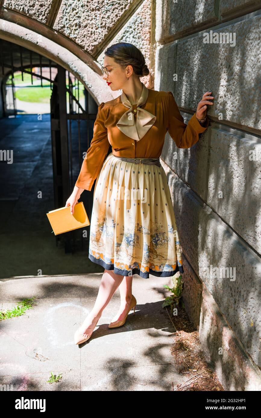 Young Woman in 1940s Outfit Posing in Victorian Era Buildings Stock Photo