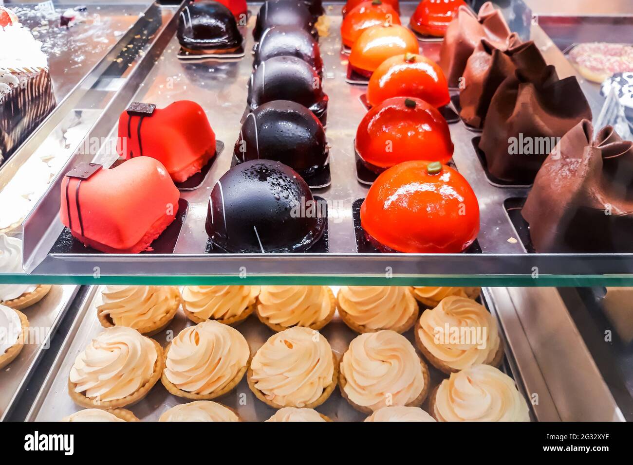Tasty sweets in window of confectionery store. Fresh pastries, donuts