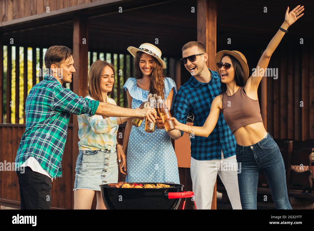 Group of young friends having fun at a party outdoors, drinking cold ...