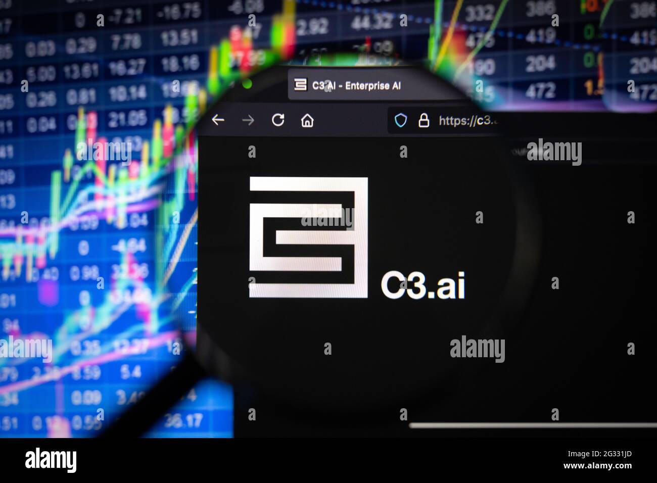 C3.ai company logo on a website with blurry stock market developments in the background, seen on a computer screen through a magnifying glass Stock Photo