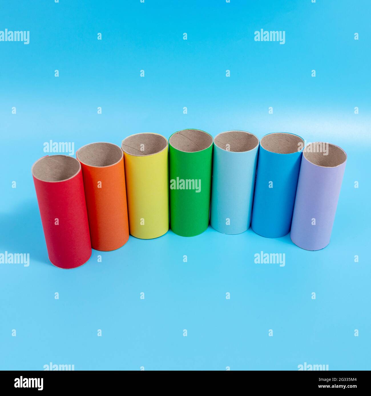 simple activity for kids, toilet paper roll craft, colorful tubes on blue background Stock Photo