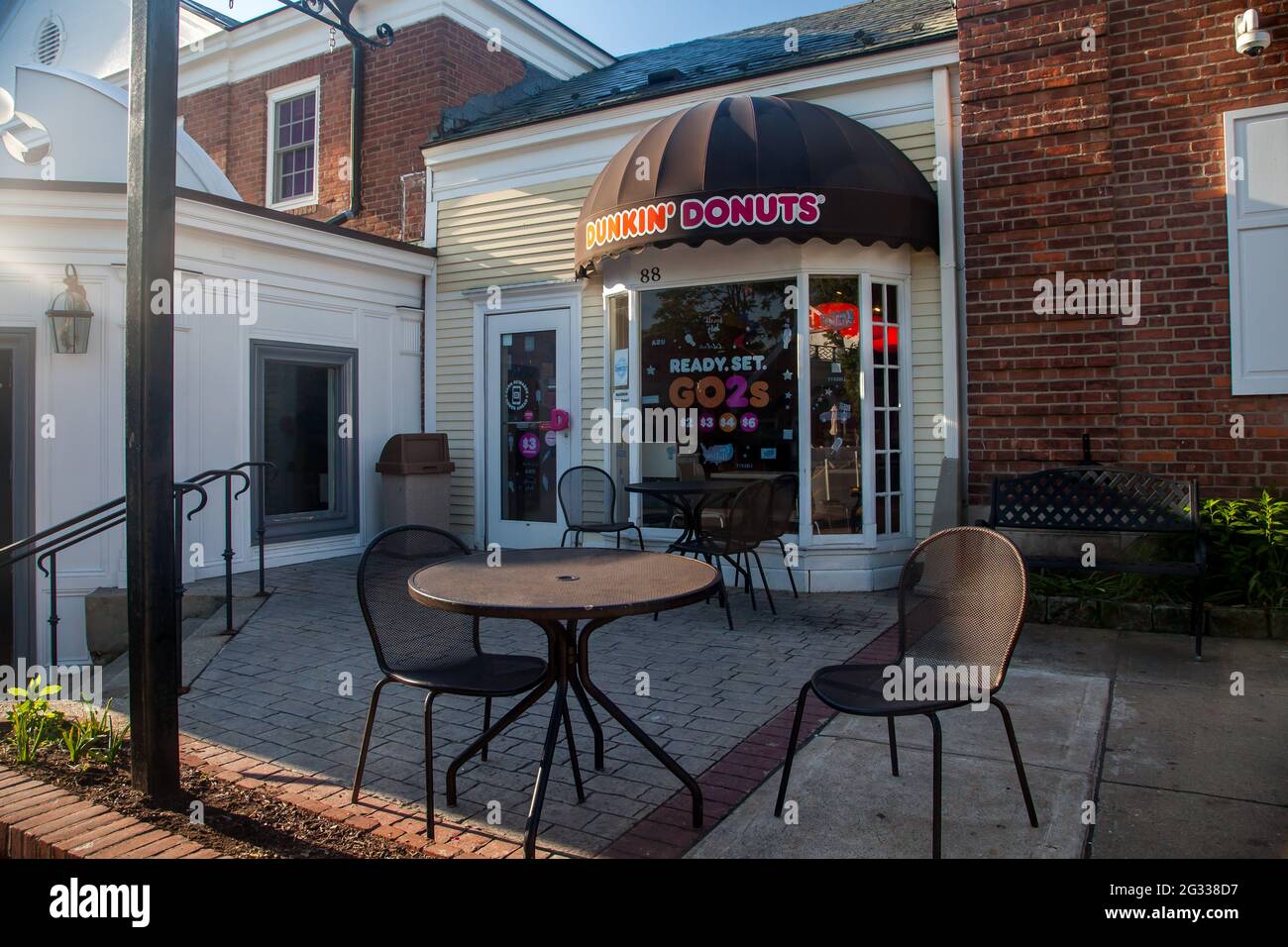 NEW CANAAN, CT, USA- JUNE 13, 2021:  Dunkin Donuts entrance with little table outdoor near Elm Street Stock Photo