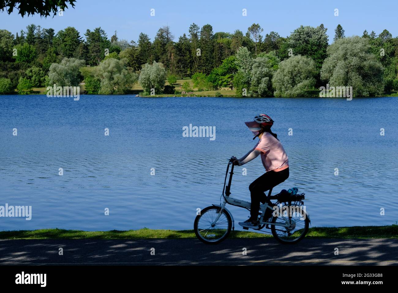 Cycling on the bike path that runs along Dow's Lake on a lovely sunny morning in Ottawa, Ontario, Canada. Stock Photo