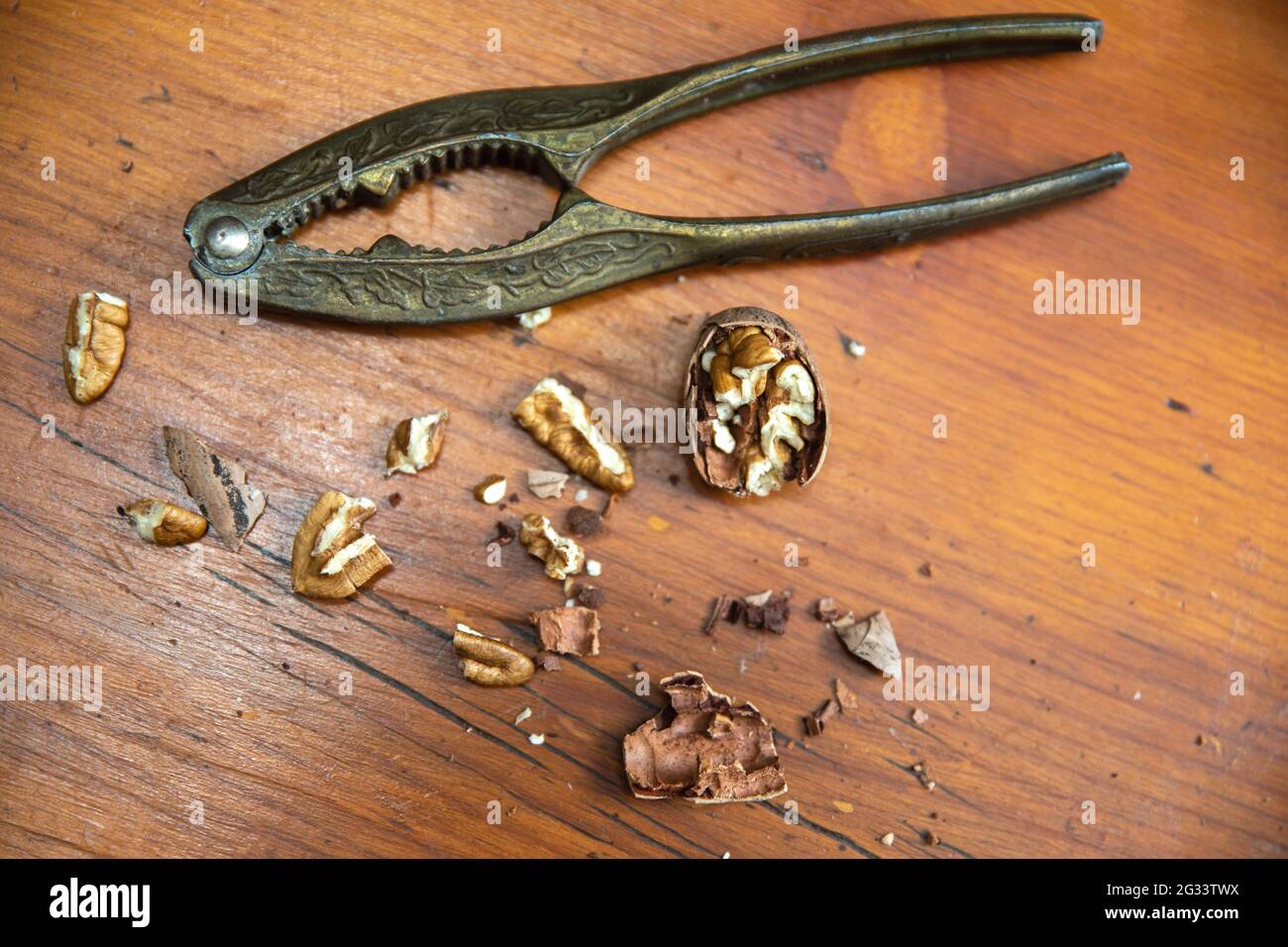 Vintage Nut Cracker with pecan nuts on a wood table Stock Photo