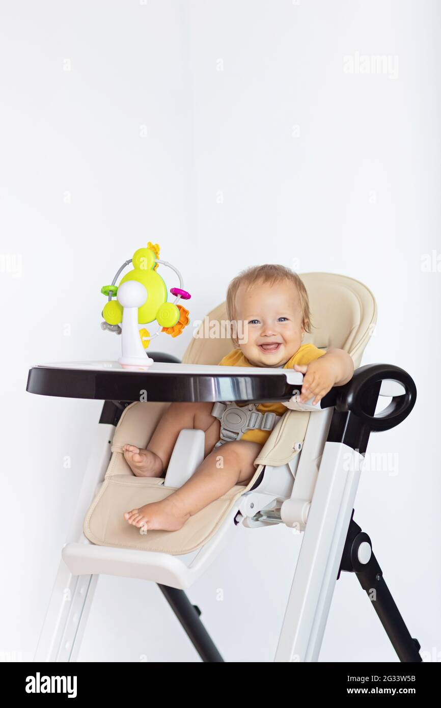 Cute caucasian infant girl ten months old sitting in baby chair and