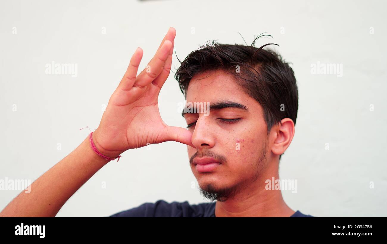 Indian young boy meditating at home. Portrait of Asian cute boy practicing yoga on white background. Worldwide yoga day concept. Stock Photo