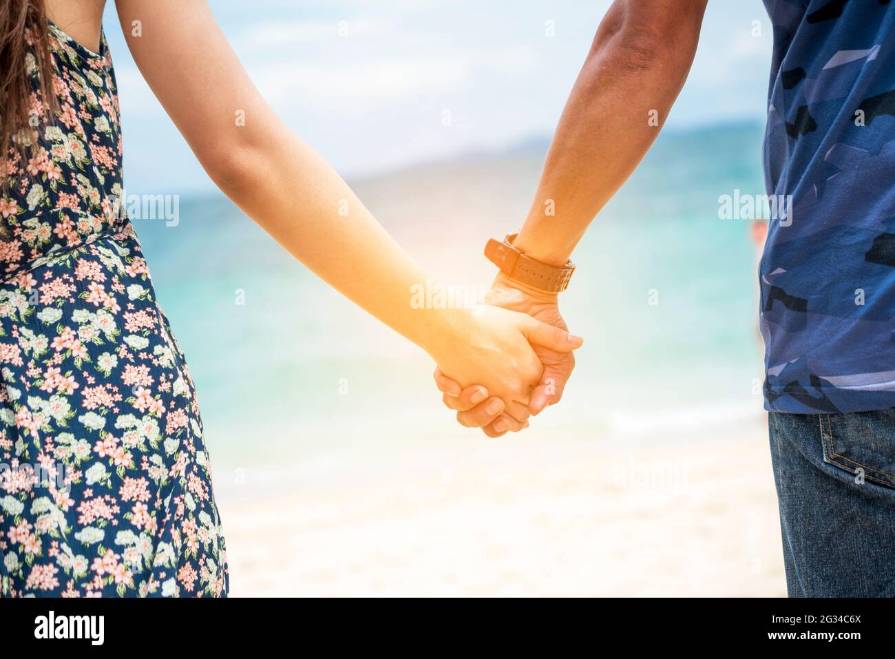 Couple lover hold hands together on tropical summer beach. Focus on