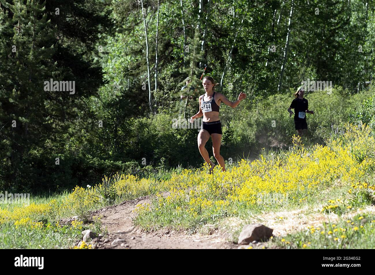 June 13, 2021: Thorton, Colorado runner, Janelle Lincks, emerges from the forest on her way to winning the Women's 2021 Addias Terrex 10K Spring Runoff at the GoPro Mountain Games, Vail, Colorado. Stock Photo