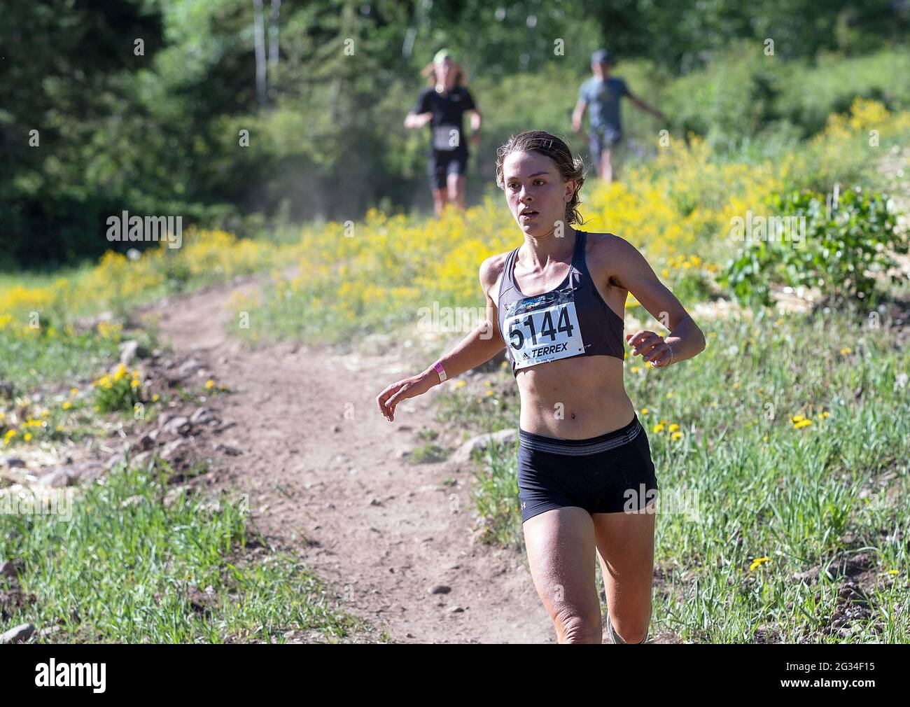 June 13, 2021: Thorton, Colorado runner, Janelle Lincks, emerges from the forest on her way to winning the Women's 2021 Addias Terrex 10K Spring Runoff at the GoPro Mountain Games, Vail, Colorado. Stock Photo