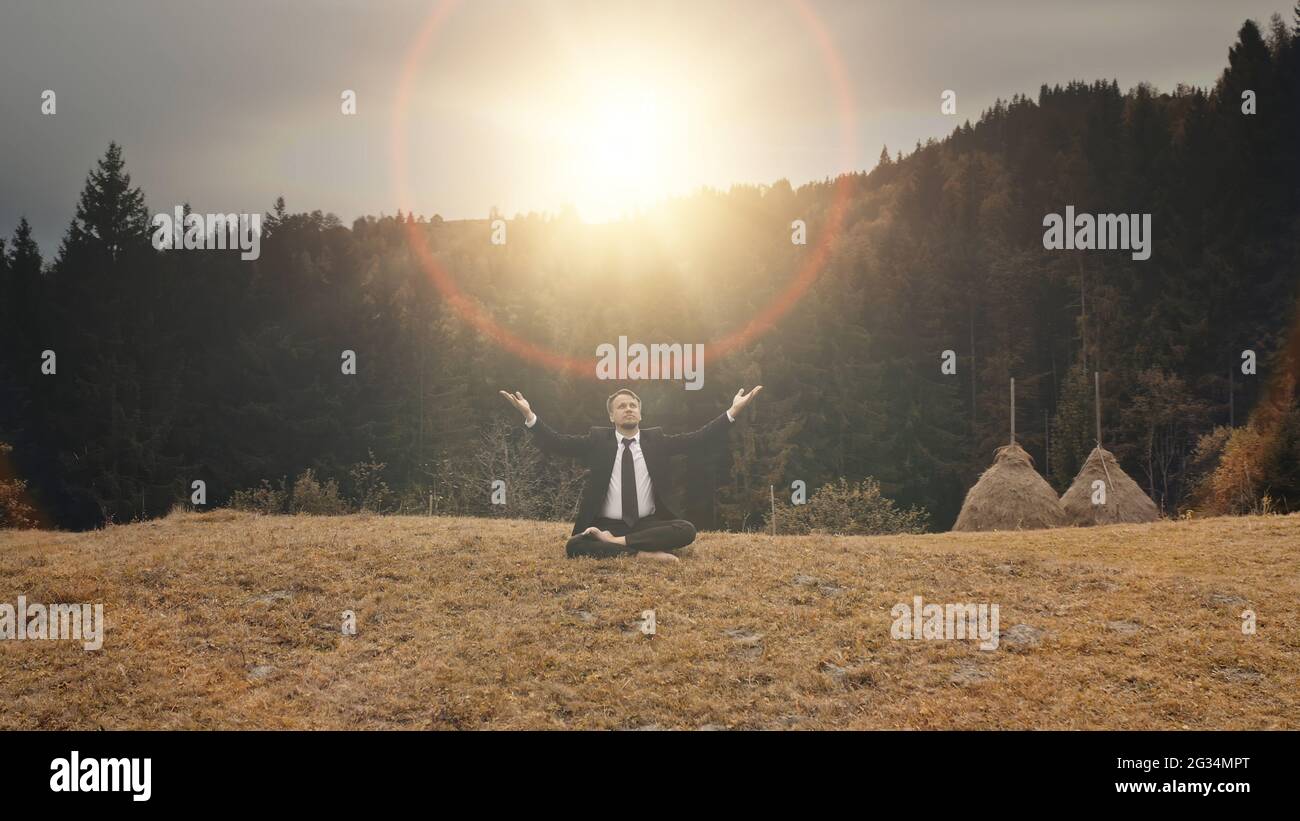 Business man rise-up hands at sun flare. Aerial nature landscape at mountain top. Businessman relax at autumn fir forest. Tourism lifestyle. Travel for recreation. Carpathians mounts, Ukraine, Europe Stock Photo