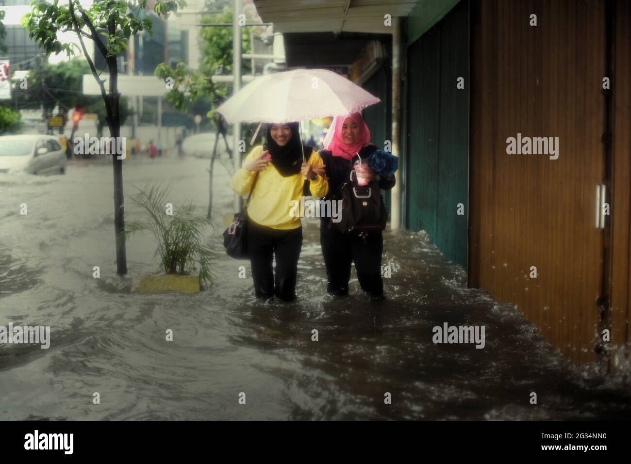 Jakarta, Indonesia. 9th February 2015. People walking through floodwater on the walkway of a commercial street in Central Jakarta, after a continuous rain left some parts of the capital city of Indonesia flooded. Stock Photo