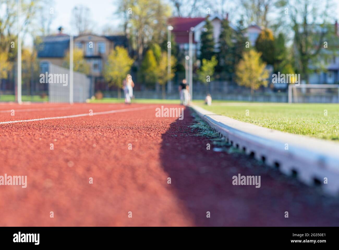 Red plastic track in the outdoor track and field stadium.Closeup. Stock Photo