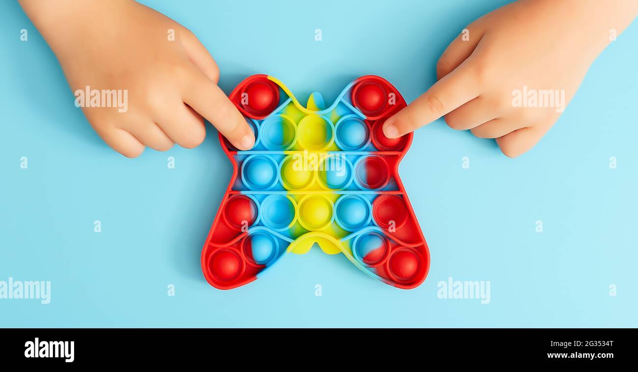 Trendy toy antistress. Anonymous child with colorful poppit game