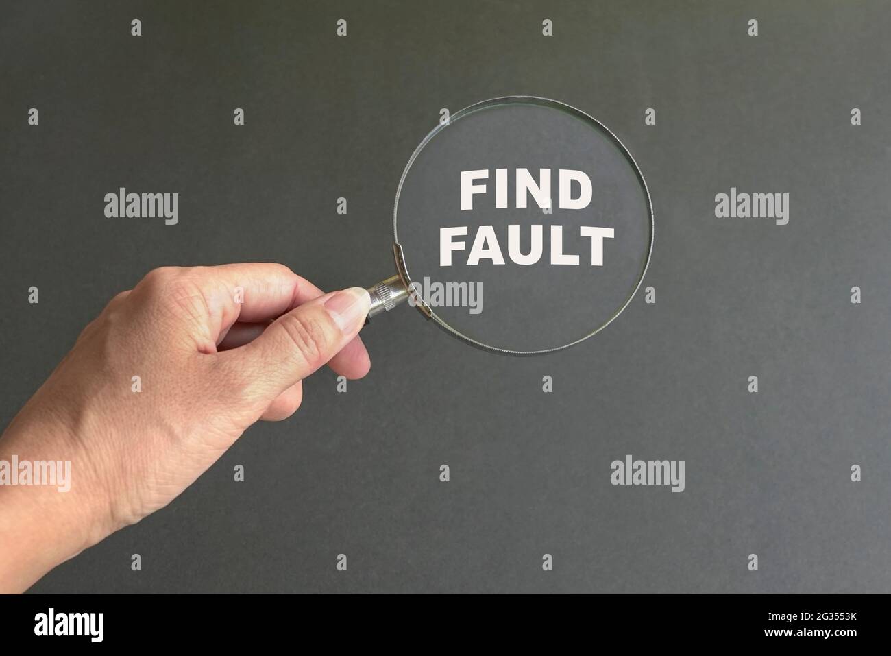 Magnifying glass with text Find Fault. Dark grey background. Stock Photo
