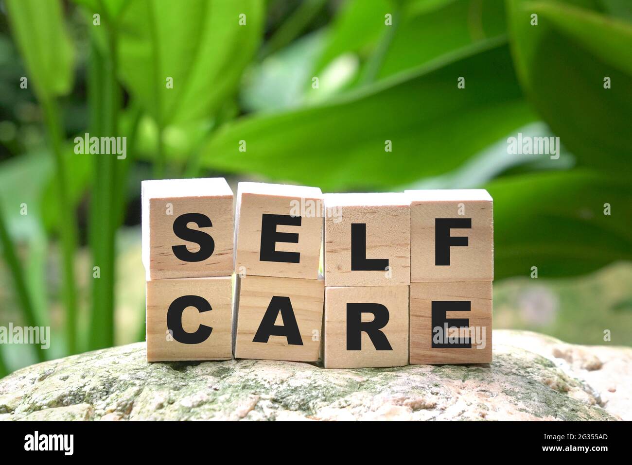 Self care word on wood cubes on green nature background. Take care of yourself message. Stock Photo