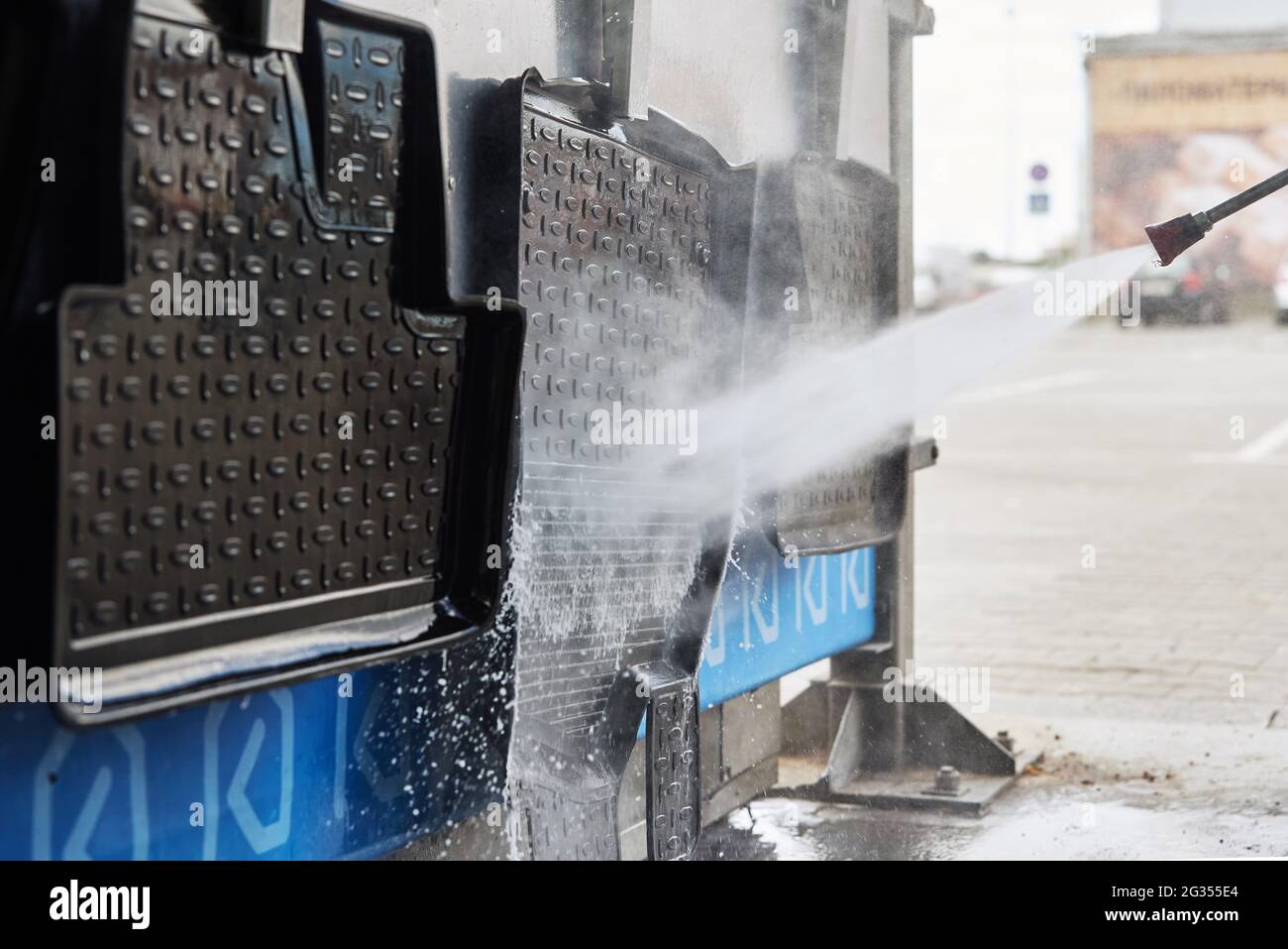 Car washing. Cleaning car rubber mat with contactless high pressure