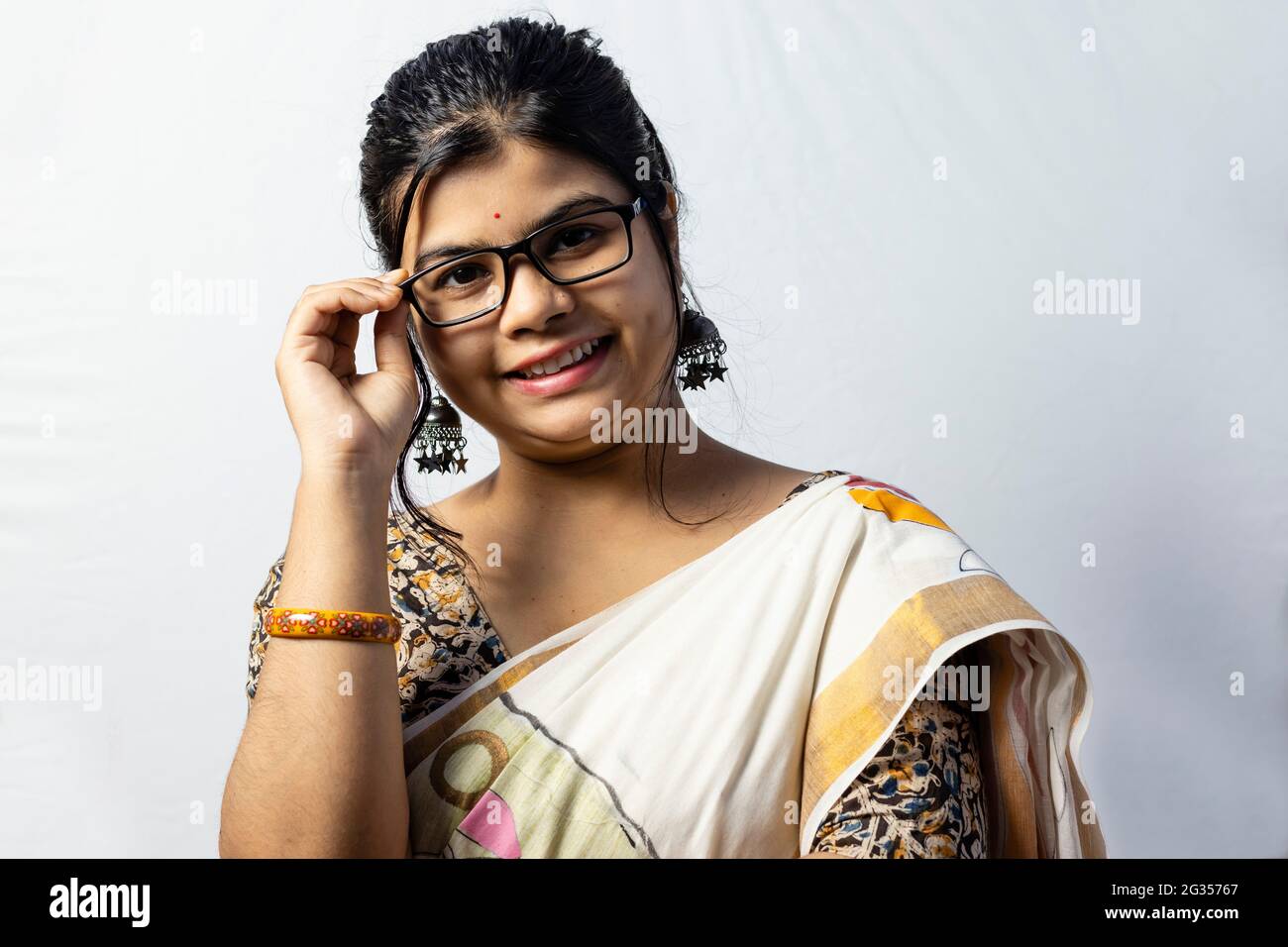 Isolated on white background an Indian office woman in saree holding her eyeglasses Stock Photo