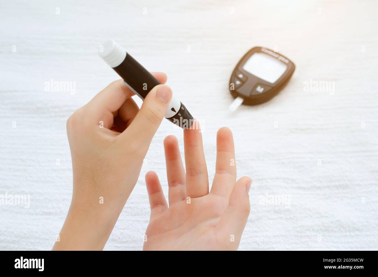 Child Hands Using Lancet on Finger to Check Blood Sugar Level by