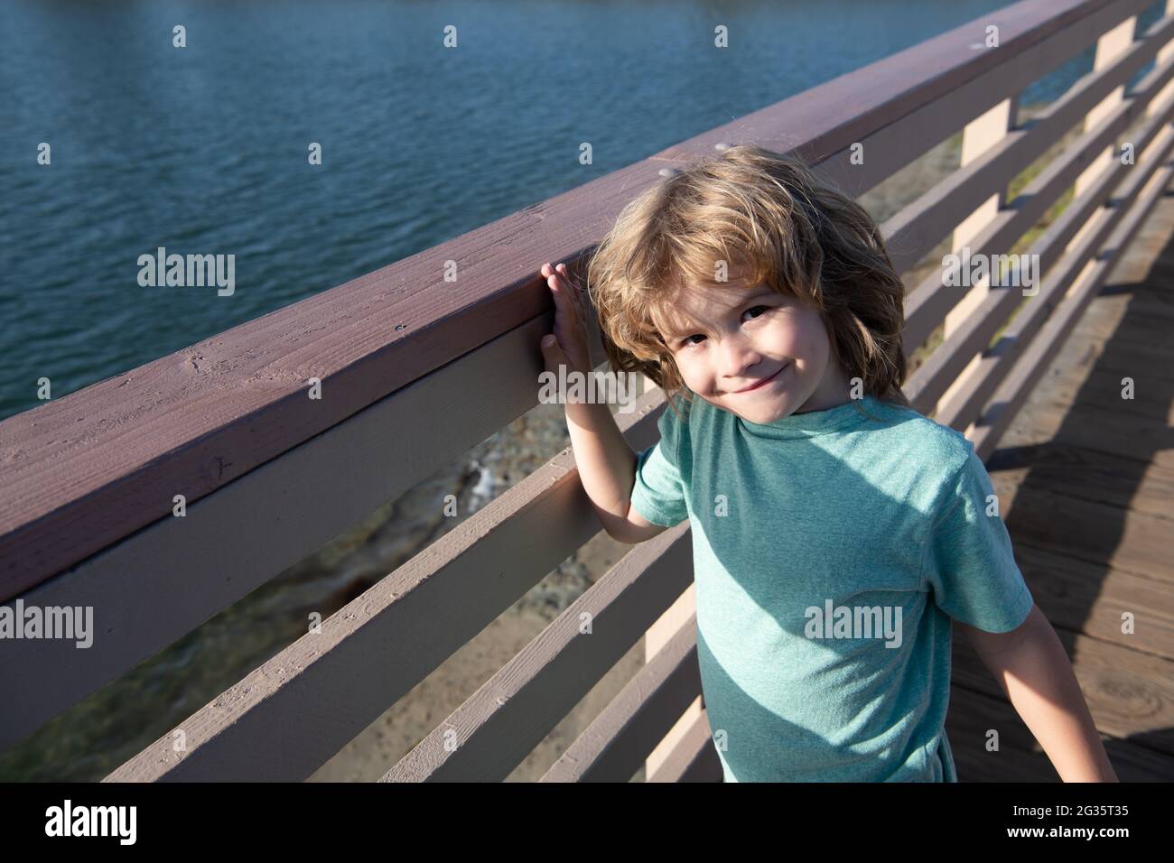 Leisure break. Happy boy child stand at promenade railing. Leisure time. Summer vacation Stock Photo