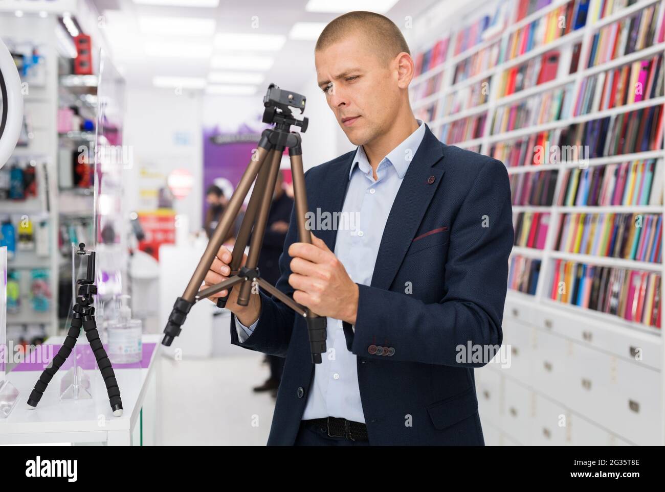 Male customer buying tripod at the multimedia store Stock Photo Alamy