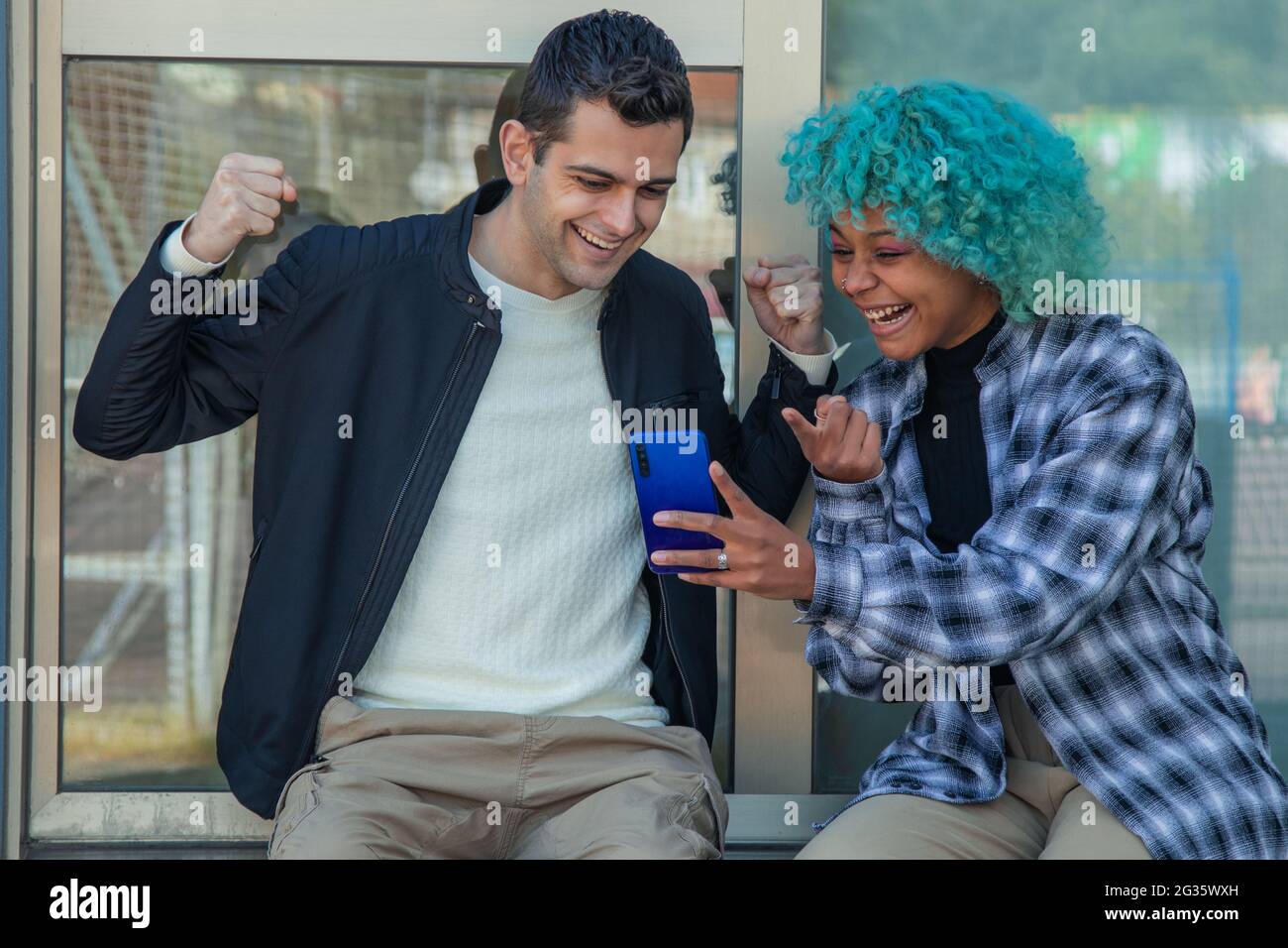 couple with mobile phone astonished celebrating Stock Photo