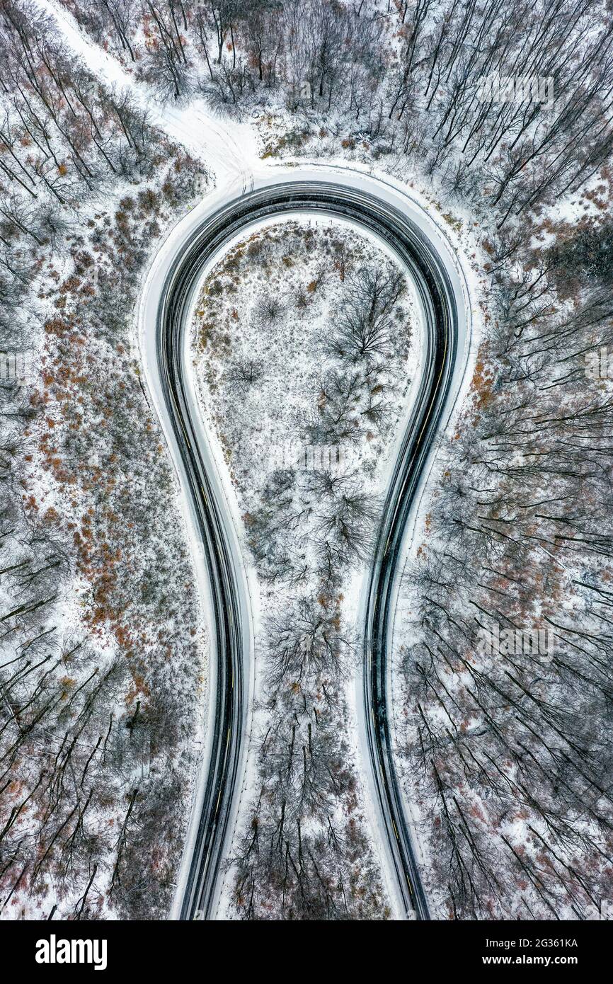 Kekesteto, Hungary - Aerial view of curvy road called the Horseshoe of Matra (Matrai patko) in snow covered forest, top down aerial view Stock Photo