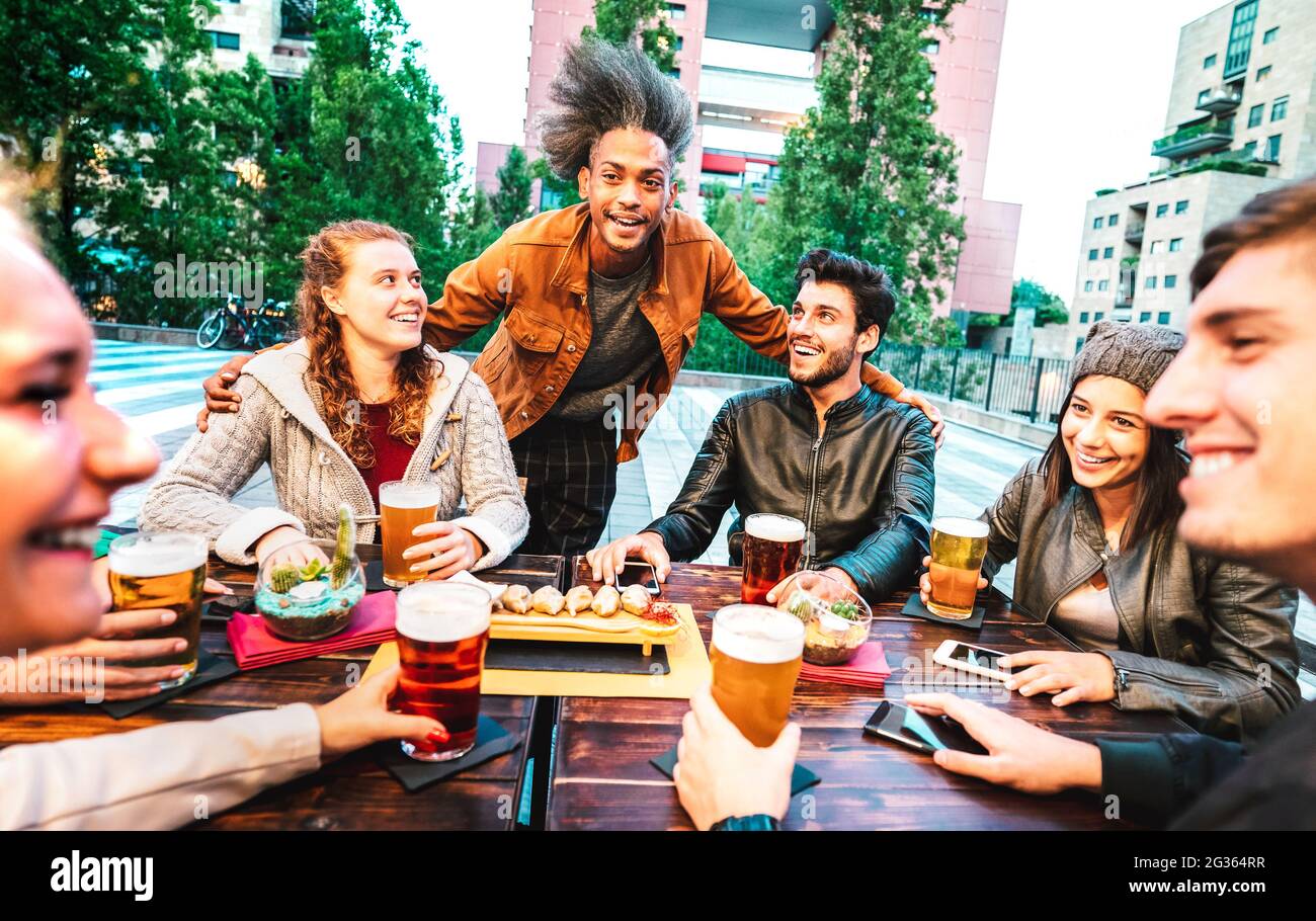 Young people drinking beer at brewery bar dehor - Friendship lifestyle concept with multicultural friends spending happy hour time together Stock Photo