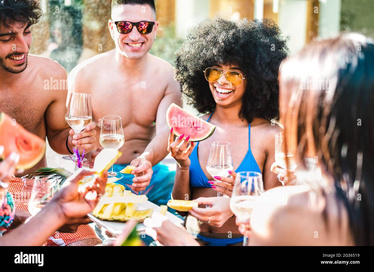 Happy friends group drinking white wine champagne at pool side party - Life style vacation concept with young guys and girls having fun together Stock Photo