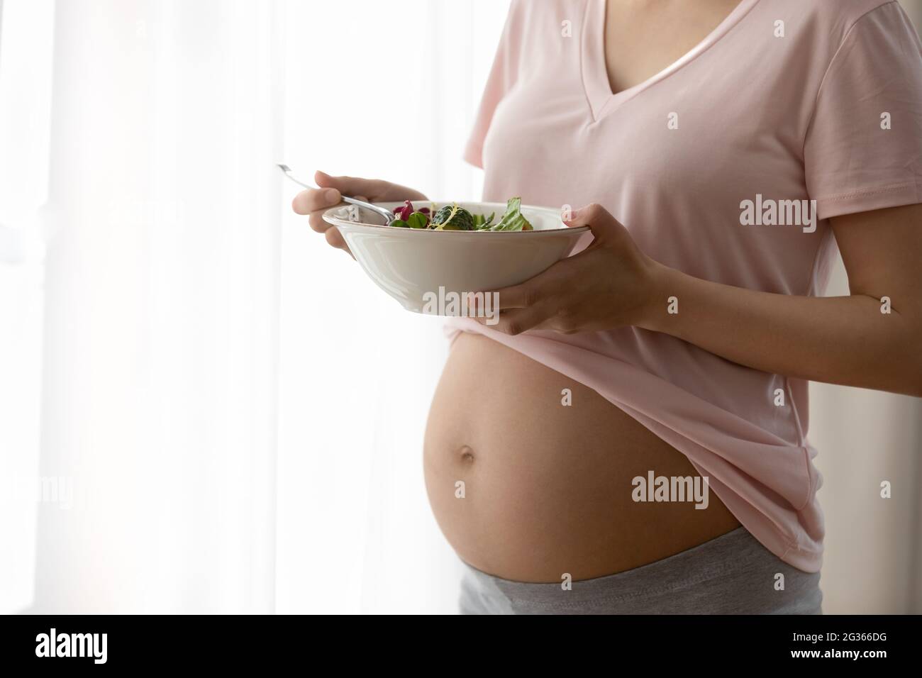 Close up cropped pregnant woman holding fresh vegetables salad Stock Photo