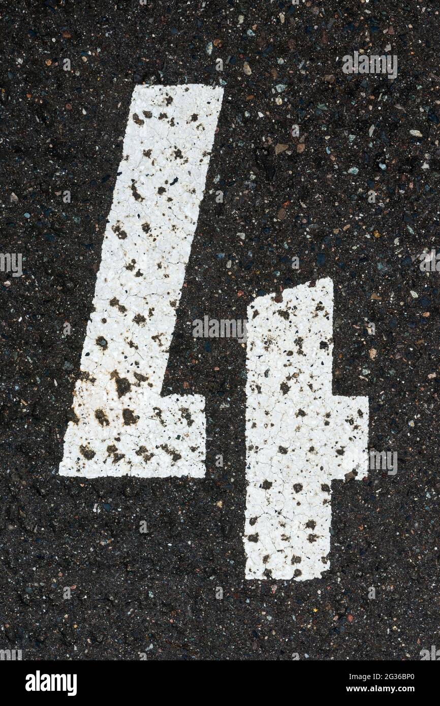 White number 4 painted on tar Stock Photo