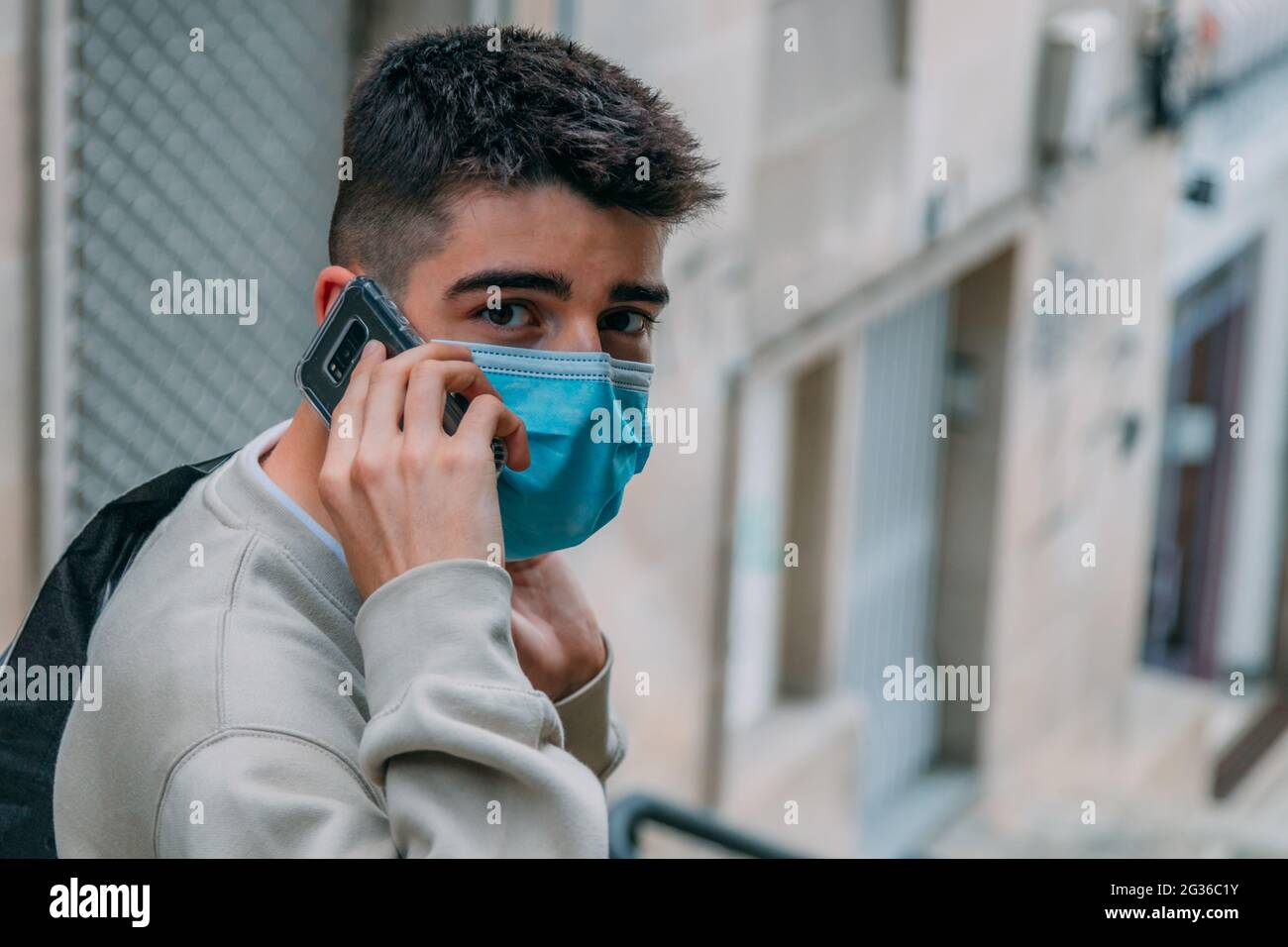 teen boy with mask talking on mobile phone in the city Stock Photo - Alamy