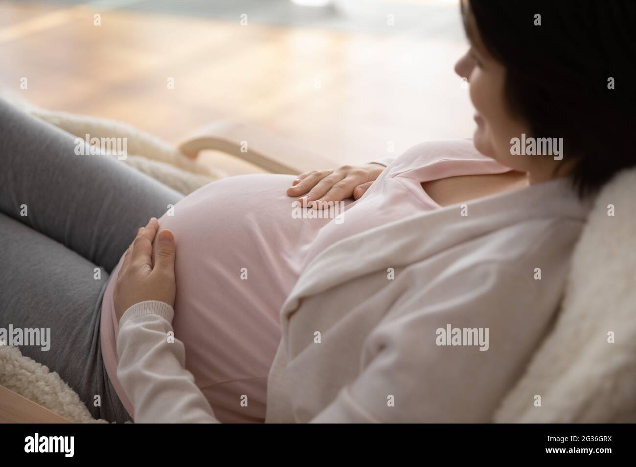 Close up young pregnant woman touching belly, expecting baby Stock Photo