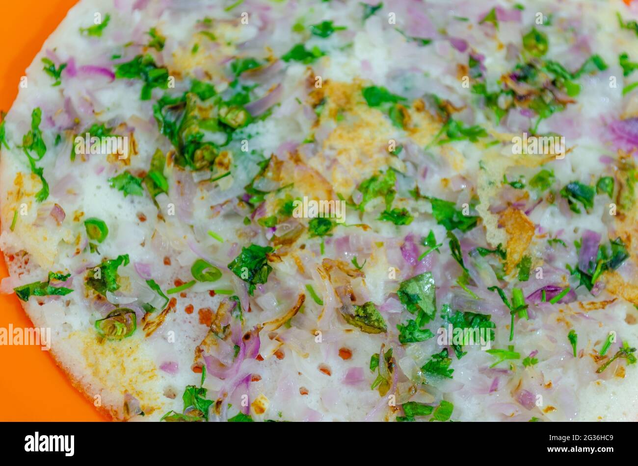 Onion Uttappam close-up shot from top. Coriander Leaves sprinkled over Stock Photo