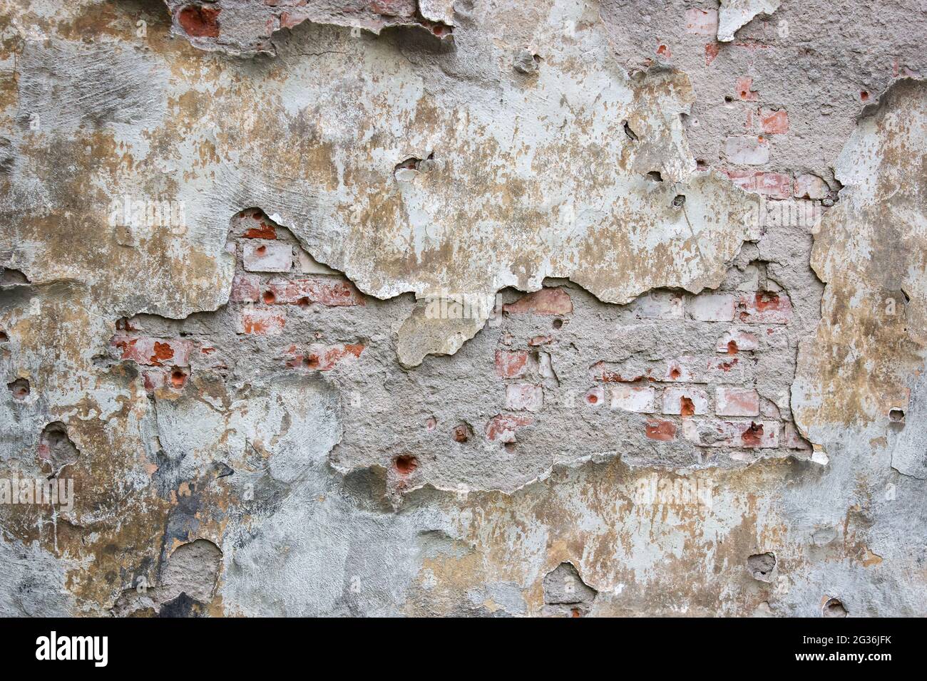 old brick wall with crumbling plaster outdoor closeup. abstract
