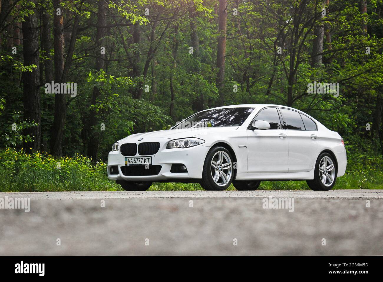 Kiev, Ukraine - May 17, 2014: White BMW 520 TDI (F10) M Sport in the forest road Stock Photo