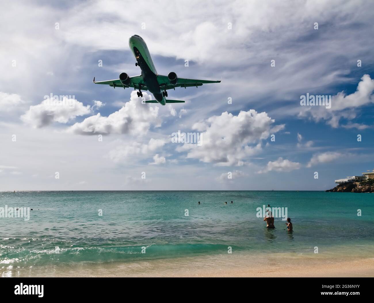 Sint Maarten, Dutch Antilles - December 04, 2015: Tourists watch from the beach as the plane lands at Princess Juliana International Airport in St. Ma Stock Photo
