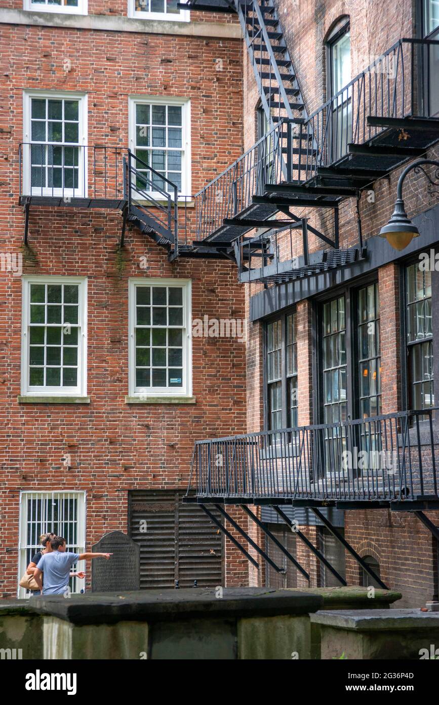 Brick apartment building with lots of fire escapes rear of King's Chapel cemetery Burying Ground, Tremont Street, Boston, Massachusetts, United States Stock Photo