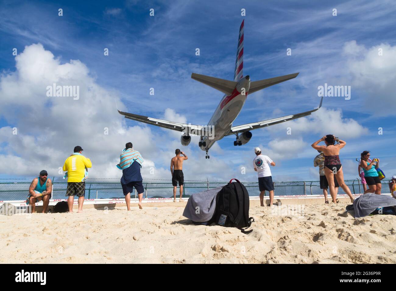 Sint Maarten, Dutch Antilles - December 04, 2015: Tourists watch from the beach as the plane lands at Princess Juliana International Airport in St. Ma Stock Photo